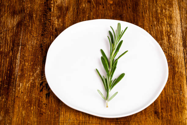 istock Fresh Rosemary on wooden background 1073905390