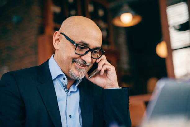 istock Close up of senior wearing suit while using smart phone and sitting in cafe. 1073905650