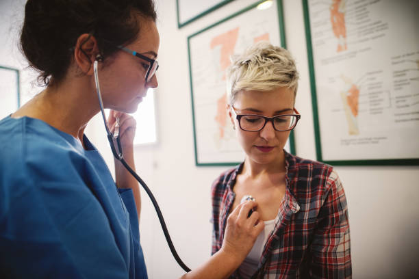 istock Female middle-aged doctor using stethoscope to examine patient. 1073909396