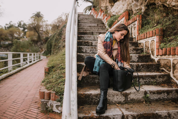 A young woman looking for something on her bag