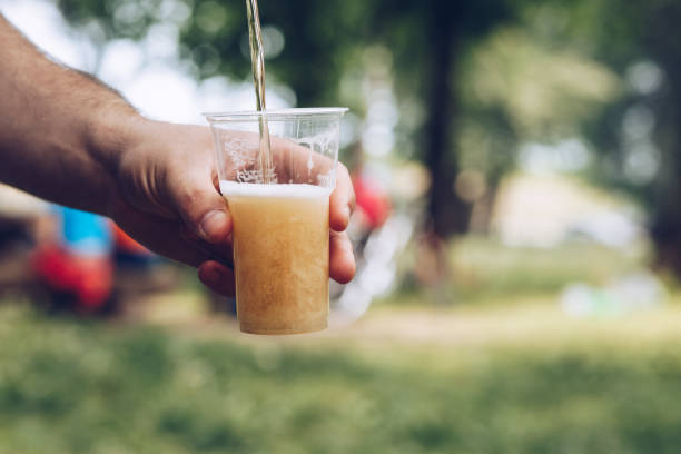 istock Man pouring beer into a cup at a picnic 1073914942