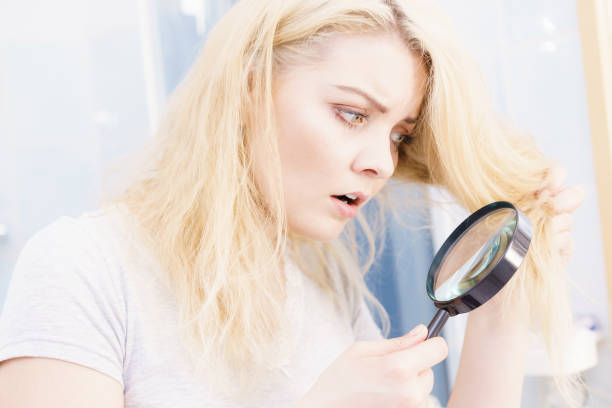 istock Woman magnifying her split ends hair 1073918248