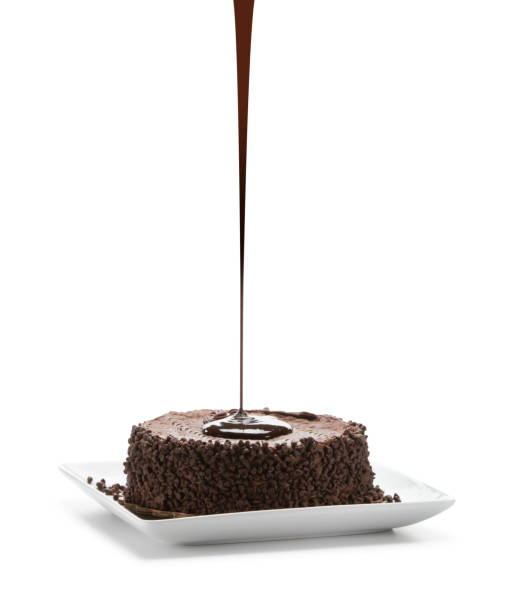 темный шоколад наливают на расплавленный лавовый торт, изолированный белым фоном - chocolate cake dessert bundt cake стоковые фото и изображения