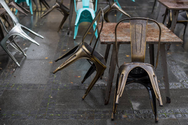Wet tables and chairs on the city street outside the restaurant after the rain. stock photo