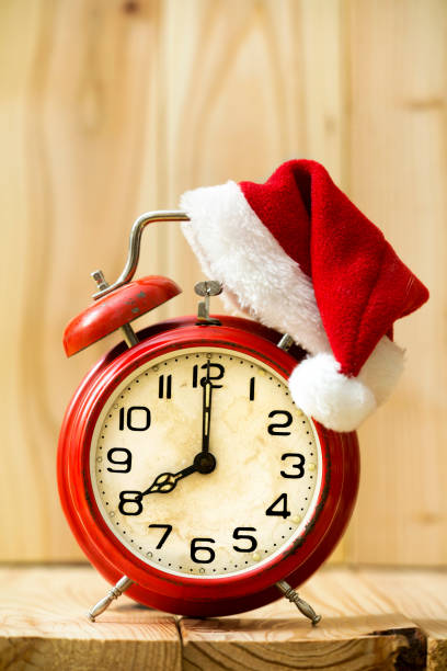 istock Christmas time - red alarm clock with santa hat 1073927694