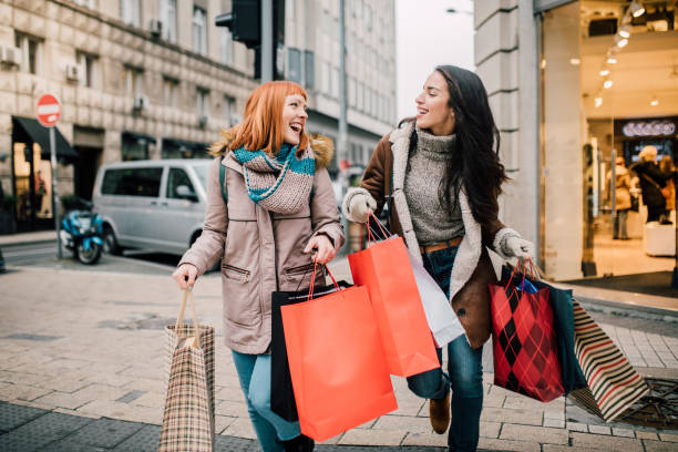 chicas llevando bolsas de compras - holiday shopping fotografías e imágenes de stock