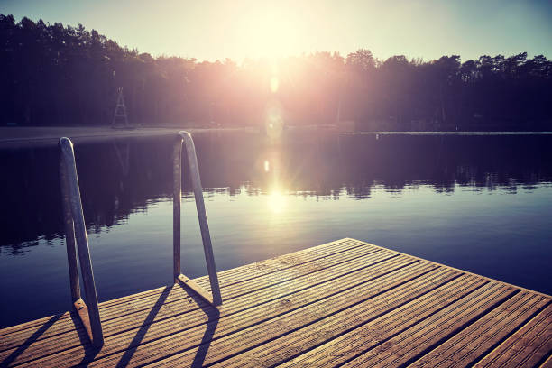 istock Vintage toned swimming platform at sunset. 1073938606