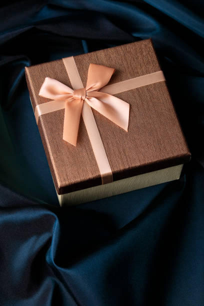 istock Golden gift box on navy blue satin background 1073939162