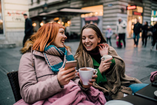 istock Girls drinking coffee and using phone 1073939632