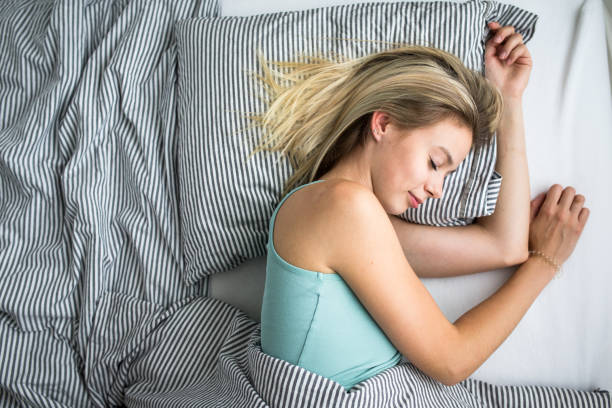 istock Beautiful young woman sleeping in bed 1073944274
