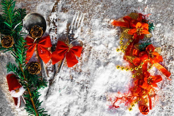 istock Christmas table set with Santa toy, tree branch, cones, bows on snowy background 1073945884