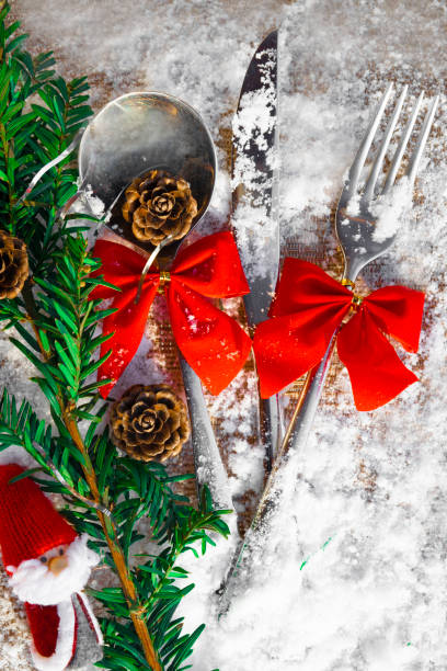 istock Christmas table set with Santa toy, tree branch, cones, bows on snowy background 1073945898