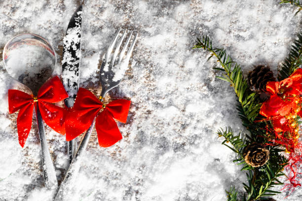 istock Christmas table set Fork, spoon and knife with decoration on snowy background 1073948190
