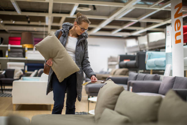 Pretty, young woman choosing the right furniture for her apartment stock photo