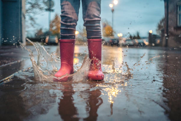 istock Little girl playing on rain in boots 1073950138