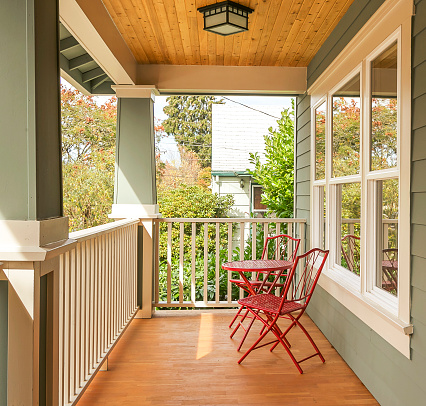 Cute and inviting front porch with red table and chairs