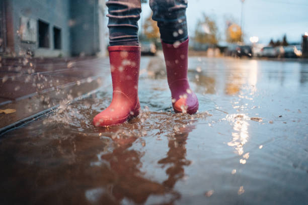 istock Little 3 year old walking on puddle 1073952836