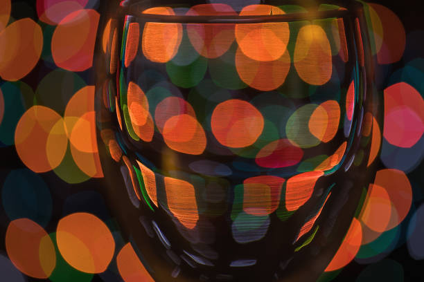 Red wine in glass with blurry christmas lights in background. Close-up