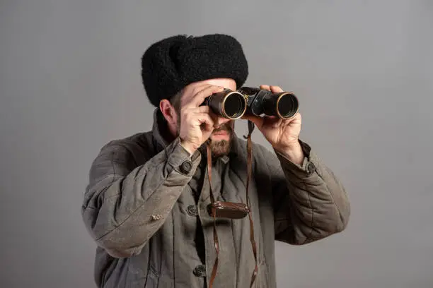 Soviet soldier with binoculars on guard, retro uniform. Second World War theme