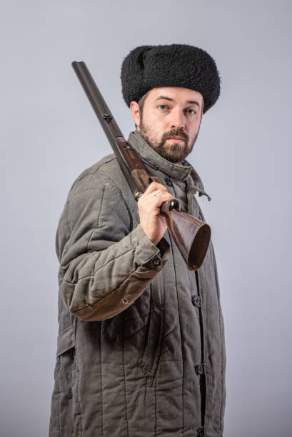istock Peasant with a rifle on his shoulder, old-fashioned clothes, studio shot 1073959818