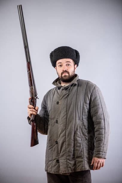 istock Hunter with horizontal double-barreled shotgun in hand, rifle is directed forward, retro style 1073959848