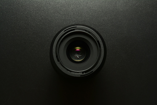 Close up of a camera lens, black background