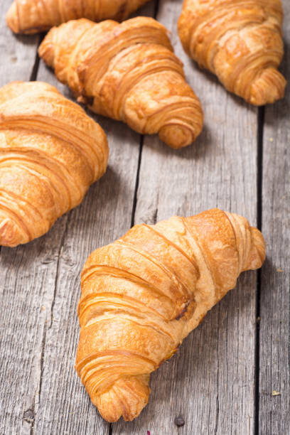 istock Croissants on wooden background 1073978314