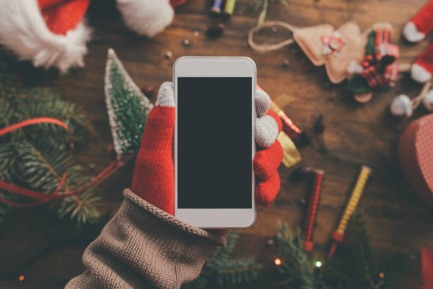 istock Smartphone in hand for Christmas season mock up 1073982842