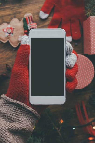 istock Smartphone in hand for Christmas season mock up 1073982864