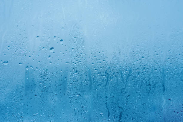 The texture of natural water drops on glass. High humidity indoor. Close-up with condensation stock photo