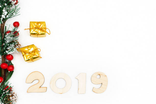 istock gold gift boxes, decorative spruce branch and symbol numbers 2019 New year on white background, simple flatley Christmas card. Selective focus 1073992996