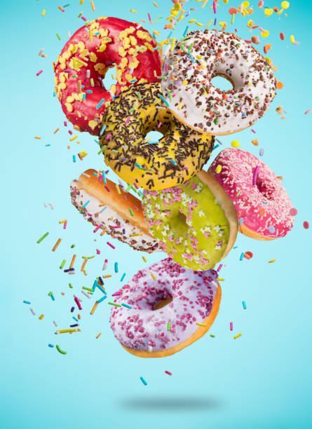 istock Tasty doughnuts in motion falling on pastel blue background. 1073994870