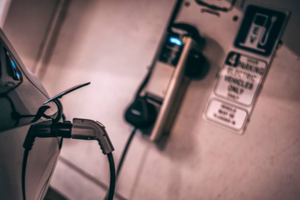 istock Power supply cable connected to an electric car (EV) at a charging station 1073997238