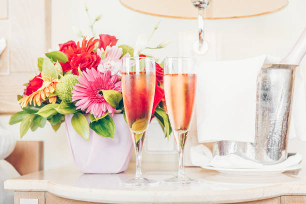 zwei gläser rose champagner auf dem zimmer hotel der gehobenen klasse. dating, romantik, flitterwochen, valentinstag, urlaub konzepte - romantic getaway stock-fotos und bilder