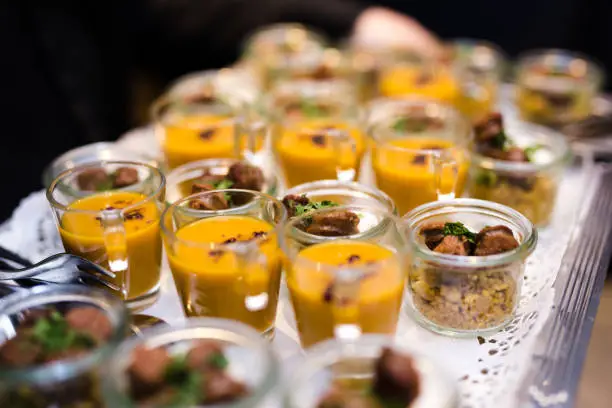 Different kinds of fingerfood being served on a silver tray at a corporate party