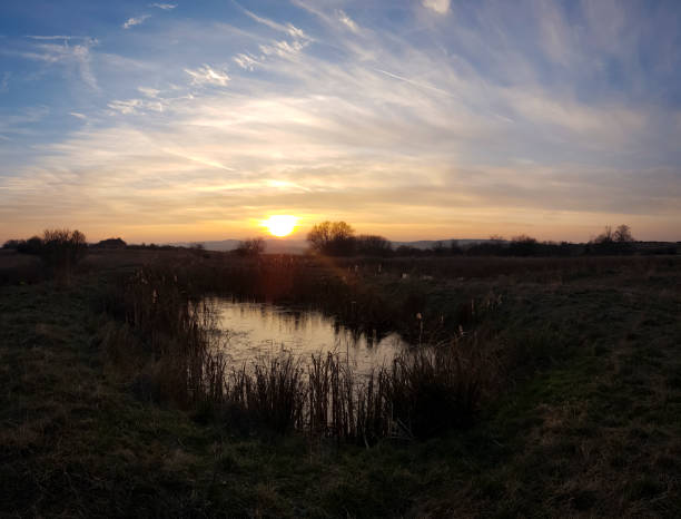 istock scenic panorama view of sunset under a cloudy sky panorama with sun reflection over water 1074025492