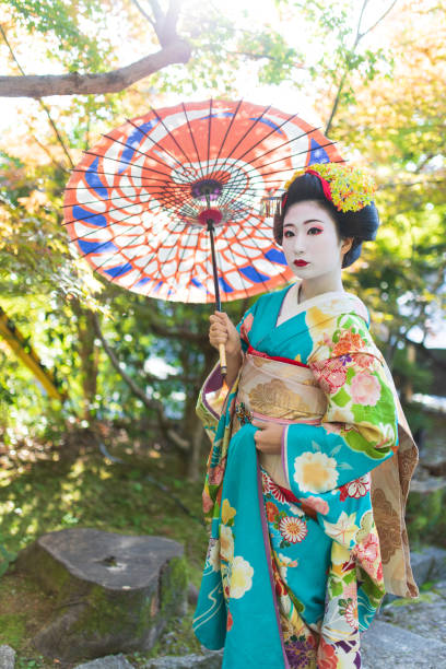 istock Maiko Apprentice Geisha standing in nature 1074030314