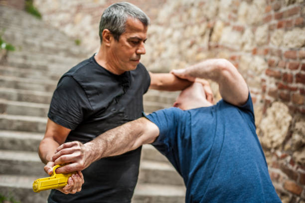 istock Gun point. Kapap instructor demonstrates self defense techniques against threat 1074037390