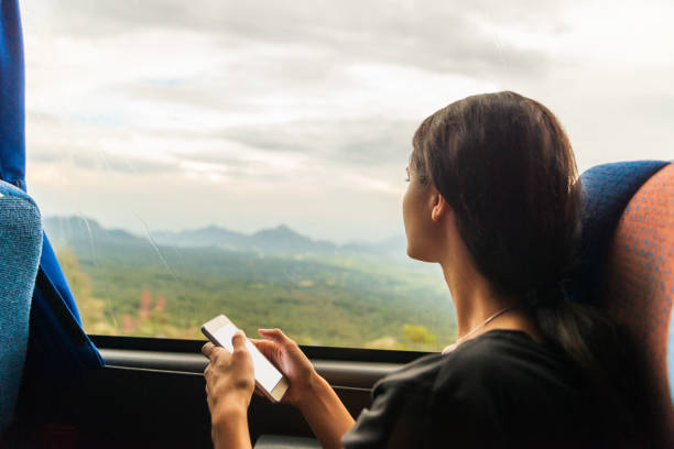 istock Young woman using mobile phone in the bus. 1074039526