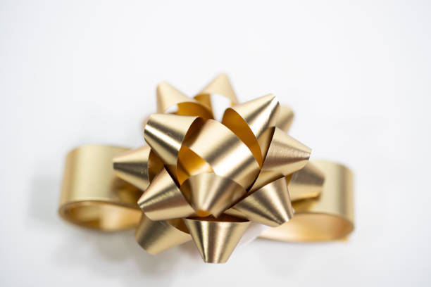 Close-up of a gift with ribbon bow on defocused lights background.