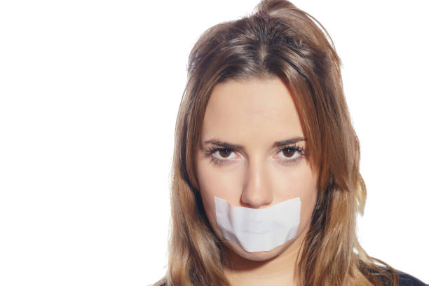 istock Blonde woman silenced with tape, removing it. 1074043272