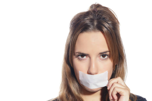 Blonde woman silenced with tape, removing it. Blonde woman silenced with tape, removing it and finally free. Isolated, over a white background. copyright free medical stock pictures, royalty-free photos & images