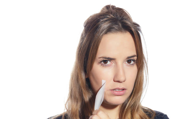Blonde woman silenced with tape, removing it. Blonde woman silenced with tape, removing it and finally free. Isolated, over a white background. copyright free medical stock pictures, royalty-free photos & images