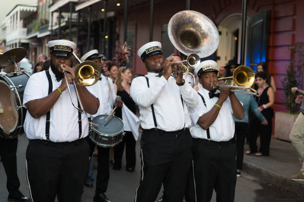 New Orleans New Orleans, USA - Nov 3, 2018: A Second Line moving down Bourbon street in the french quarter late in the day. new orleans stock pictures, royalty-free photos & images