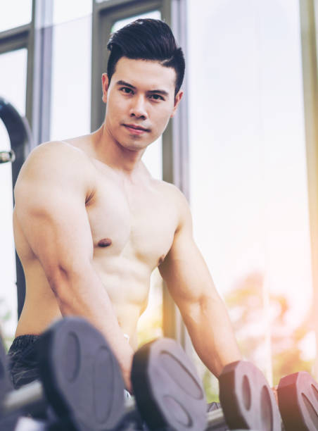 istock Muscular man bodybuilder training with dumbbells. 1074059992