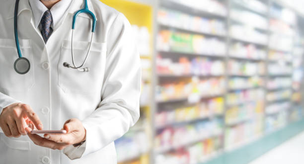 Male pharmacist using mobile phone at pharmacy.