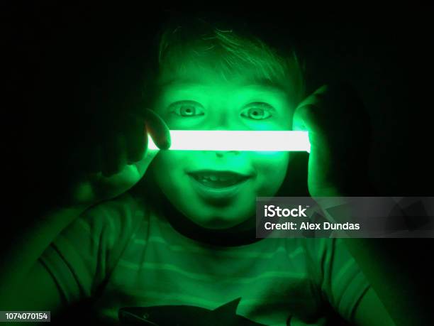 Smiling Boy With Glow Stick Dark Background Stock Photo - Download Image Now - Glow Stick, Child, Neon Lighting