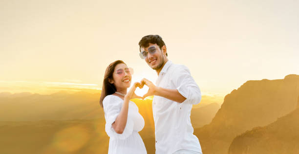 istock Happy couple making heart sign gesture with hands. 1074072616