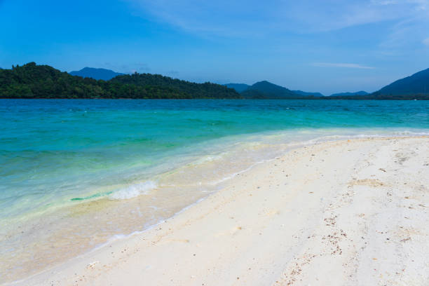 istock White sand beach and turquoise sea with mountain background 1074074876