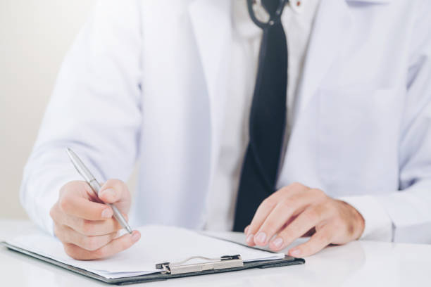 istock Doctor in hospital writing on a paper document. 1074077062
